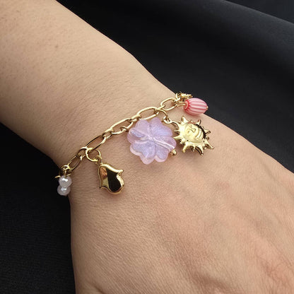 Bracelet Doré à Maillons Ovales Orné de Charms Célestes et Trèfles à Quatre Feuilles Roses